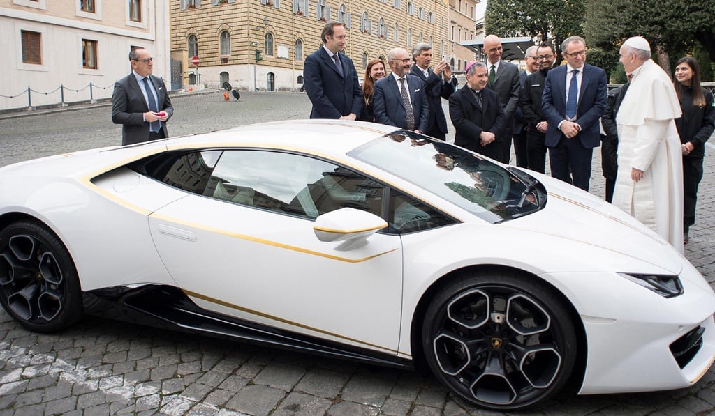 Pope Francis speaks to Lamborghini’s chief executive officer Stefano Domenicali beside the Lamborghini Huracán, which was donated to him by the luxury sports carmaker. Photo: AP