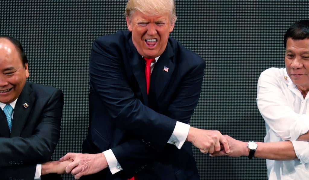 Donald Trump smiles with other leaders, including Vietnam's prime minister, Nguyen Xuan Phuc (left), and Rodrigo Duterte, as they cross arms for the traditional