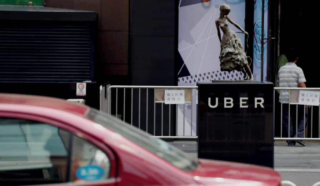 A taxi passes an Uber station outside a shopping mall in Beijing in August 2016, after Uber agreed to merge its China operations with Didi Chuxing, ending a ferocious battle for market share. Photo: AFP