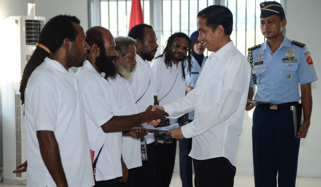 Indonesia’s President Joko Widodo shakes hands with freed Papuan political prisoners in 2015. Photo: AFP