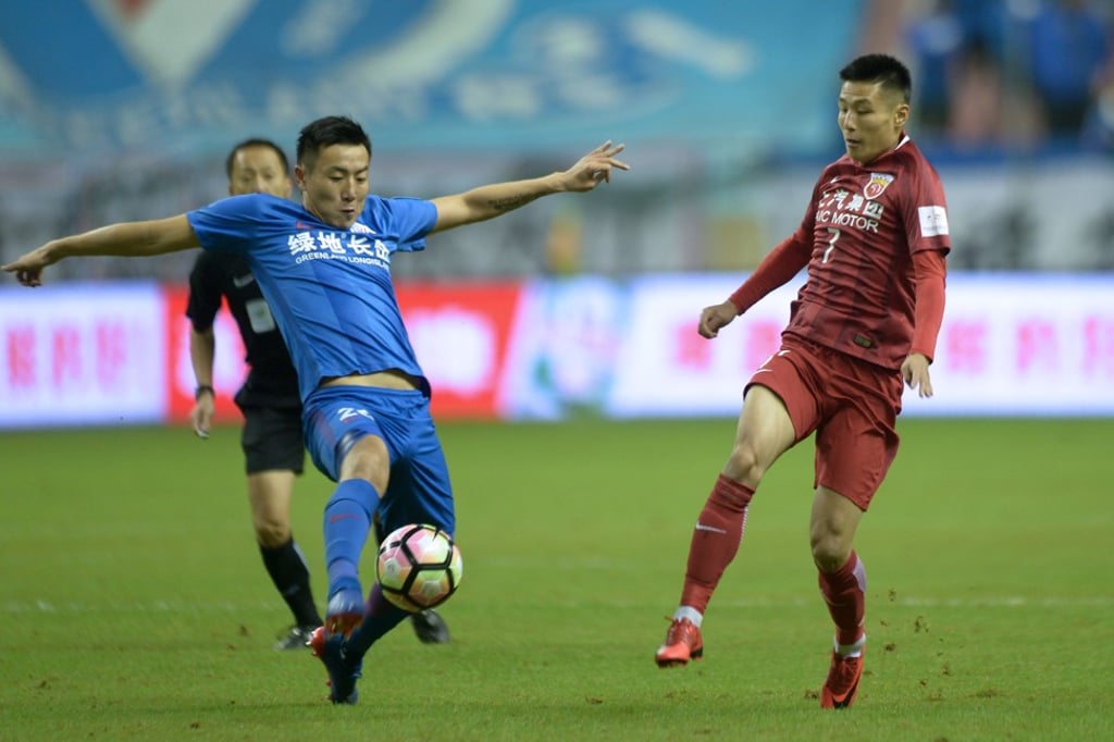 Shanghai Shenhua’s Qin Sheng blocks an effort from Shanghai SIPG’s Wu Lei. Photo: AFP