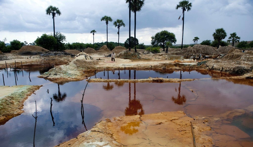 A worker walks by pools in a mining waste dump area in Monywa, northwestern Myanmar, in August 2013. Villagers whose lands were grabbed under the former junta in the copper-rich region use discarded soil from nearby mines, mixed with old aluminium cans, water and acid, to retrieve copper from the waste, exposing themselves to health hazards to eke out a meagre living. Photo: AFP