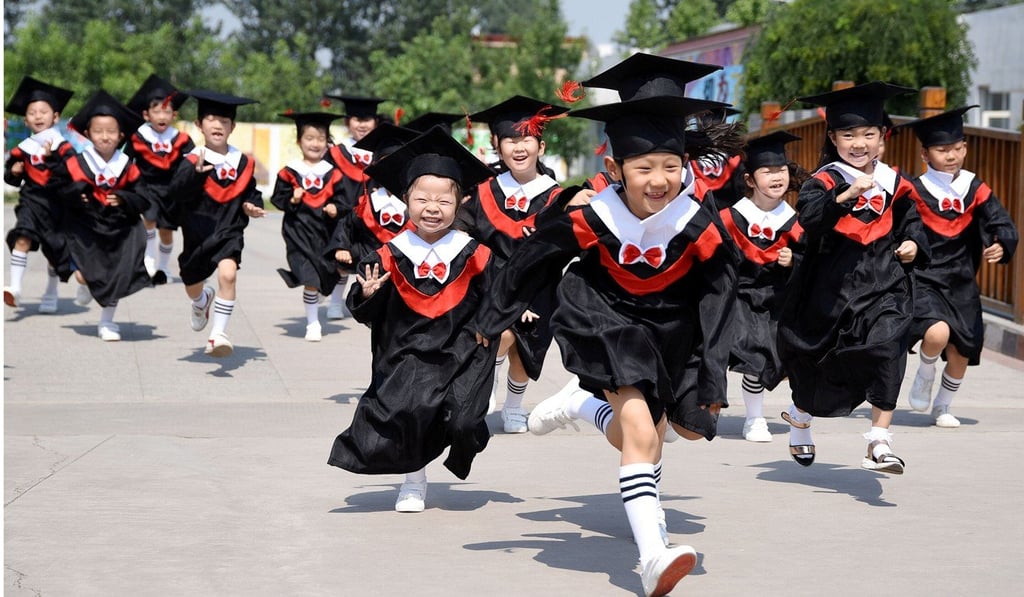 Children in gowns and mortarboards run with smiles during their kindergarten graduation ceremony in a kindergarten in Handan, Hebei province, China. Photo: REUTERS