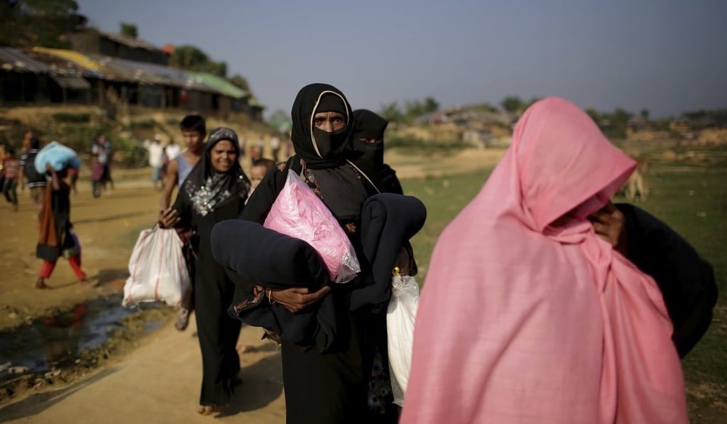Rohingya Muslim women carry blankets and other supplies collected from aid distribution centres in Kutupalong refugee camp in Bangladesh. Photo: AP Rohingya Muslim women carry blankets and other supplies collected from aid distribution centres in Kutupalong refugee camp in Bangladesh. Photo: AP