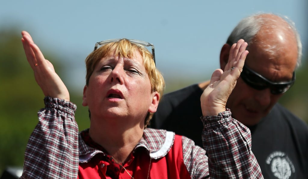 A woman prays for the 44 crew members of the missing ARA San Juan submarine at the entrance of an Argentine Naval Base in Mar del Plata, Argentina, on November 22, 2017. Photo: Reuters