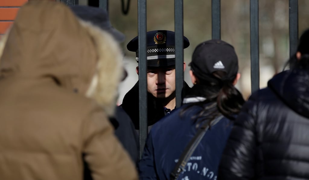 A security guard is pictured through the gates of the RYB kindergarten at the centre of a police investigation in Beijing on Friday. Photo: Reuters