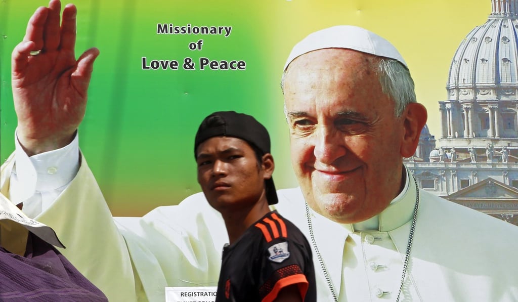A man walks past a poster welcoming Pope Francis in Yangon. Photo: EPA A man walks past a poster welcoming Pope Francis in Yangon. Photo: EPA