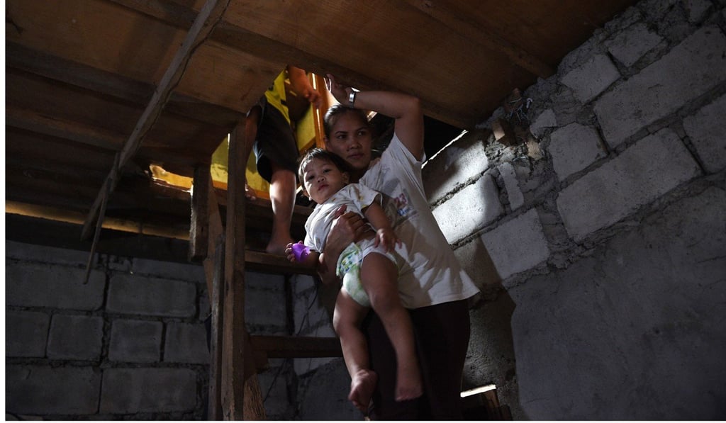 Myrna Albos walks to her house in a slum area in Manila. Photo: AFP