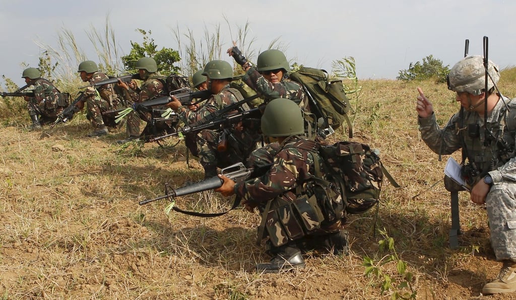 A US soldier (R) of the 2nd Stryker Brigade Combat Team gives instruction to his counterpart from the Philippine military during their annual war games at Fort Magsaysay, Nueva Ecija in the northern Philippines. Photo: Reuters