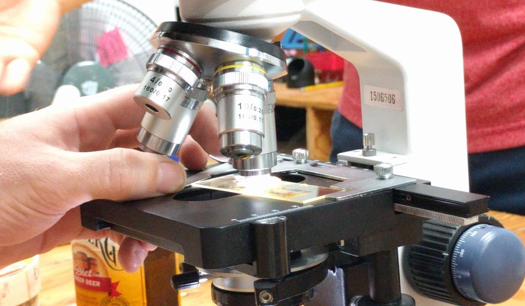 A student masters a microscope at the academy.