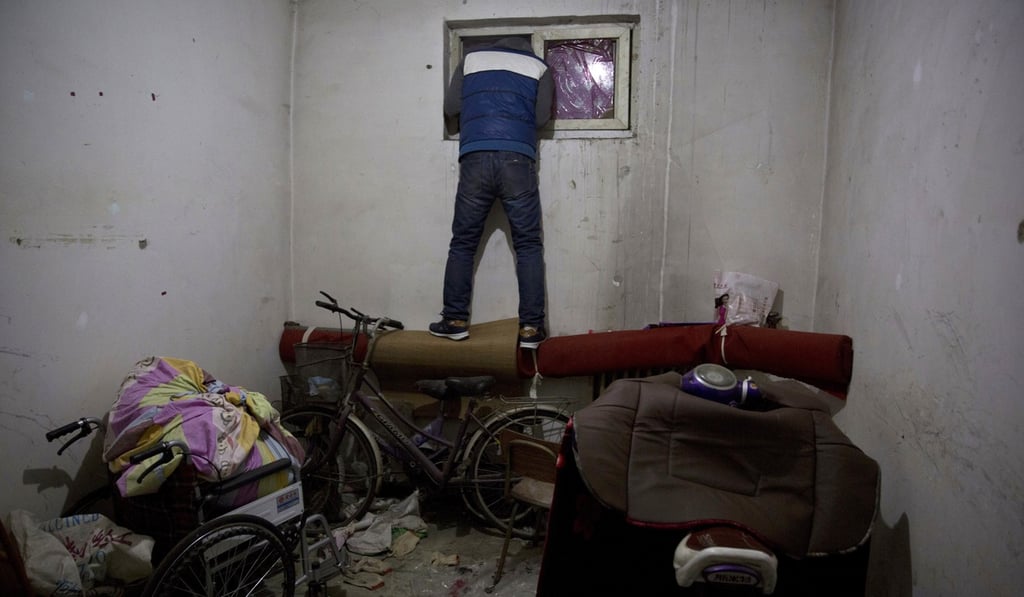 A man looks outside the window of a flat where migrant workers stayed on the outskirts of Beijing, on November 27. The Beijing authorities have introduced a raft of measures to try to force “foreigners” out of the city. Photo: AP A man looks outside the window of a flat where migrant workers stayed on the outskirts of Beijing, on November 27. The Beijing authorities have introduced a raft of measures to try to force “foreigners” out of the city. Photo: AP