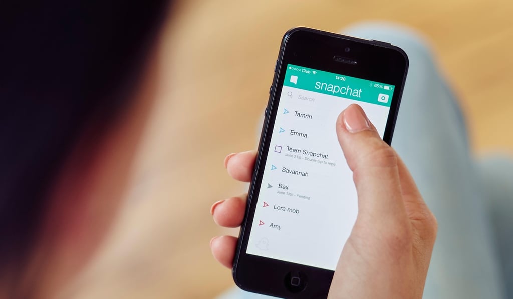 A person uses the Snapchat app on their iPhone. Photo: Alamy