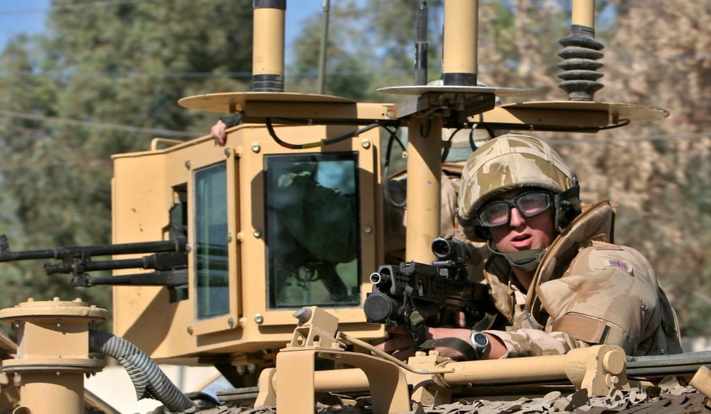 A British soldier holds his position atop an armoured vehicle during a patrol in Basra, southern Iraq, in 2006. Photo: AP