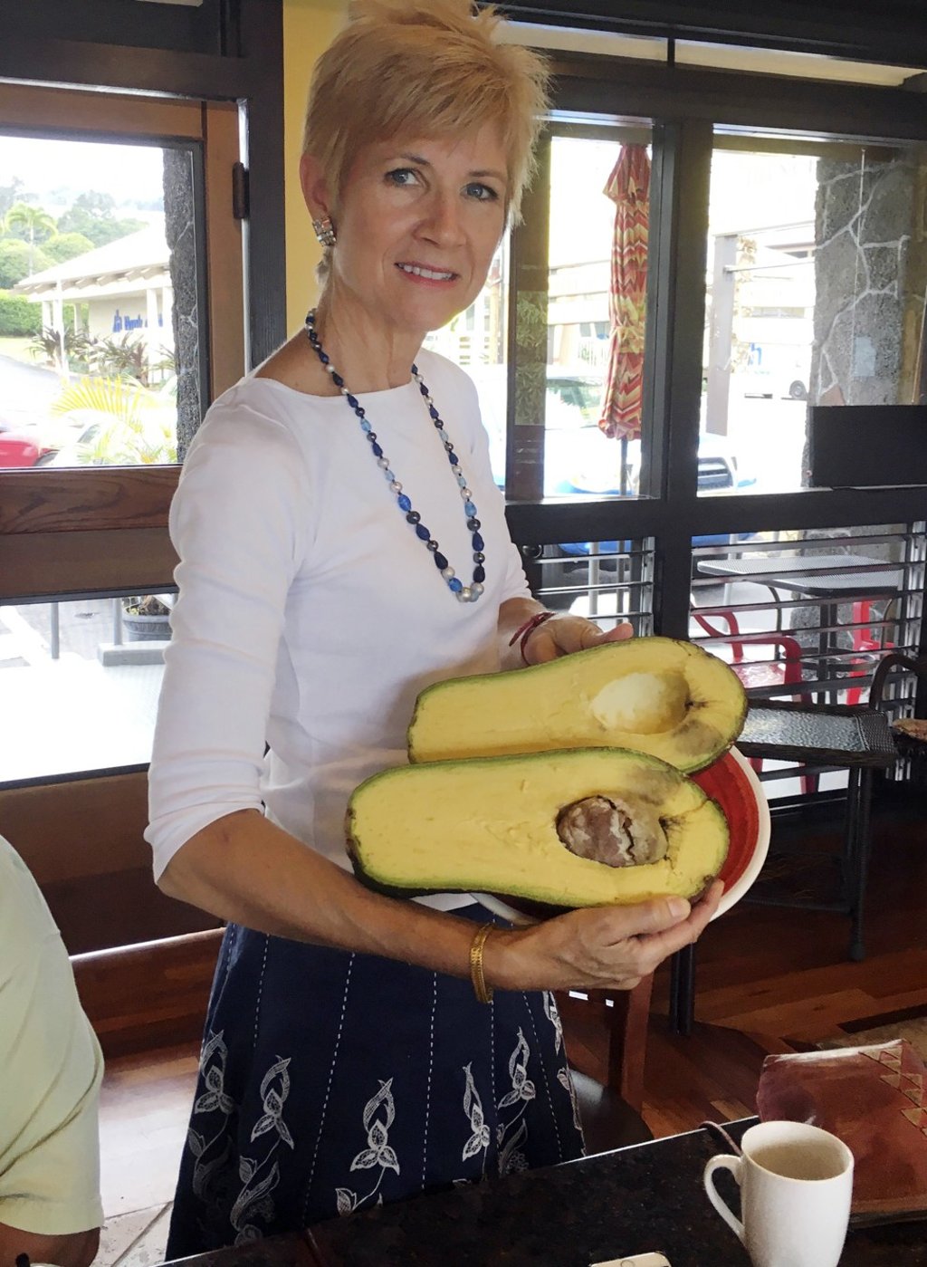 Pamela Wang poses for a photo in Kealakekua, Hawaii, with an avocado she found while on a walk. Photo: AP Pamela Wang poses for a photo in Kealakekua, Hawaii, with an avocado she found while on a walk. Photo: AP