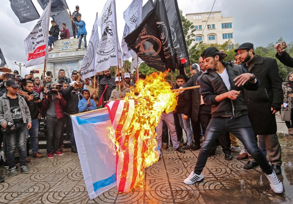 Palestinian protesters burn the US and Israeli flags in Gaza on Wednesday. US President Donald Trump was set to recognise Jerusalem as Israel’s capital, upending decades of careful US policy and ignoring dire warnings from Arab and Western allies. Photo: AFP