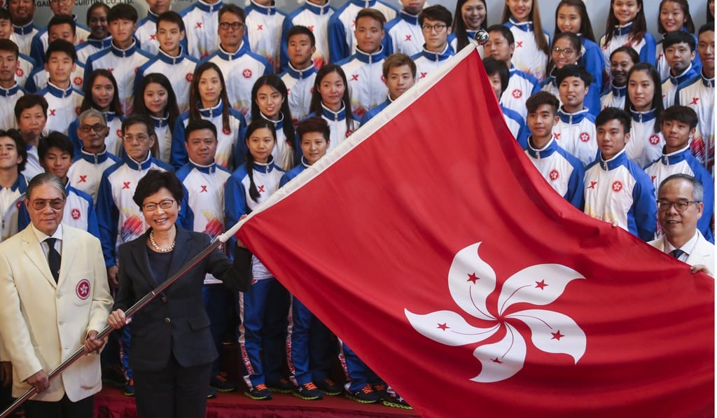 Hong Kong Chief Executive Carrie Lam (centre), Timothy Fok (left), president of Hong Kong Olympic Committee, and Secretary for Home Affairs Lau Kong-wah (far right) pose for a photo with the Hong Kong delegation to the National Games in Tianjin, during the flag presentation ceremony on August 10. Photo: K. Y. Cheng