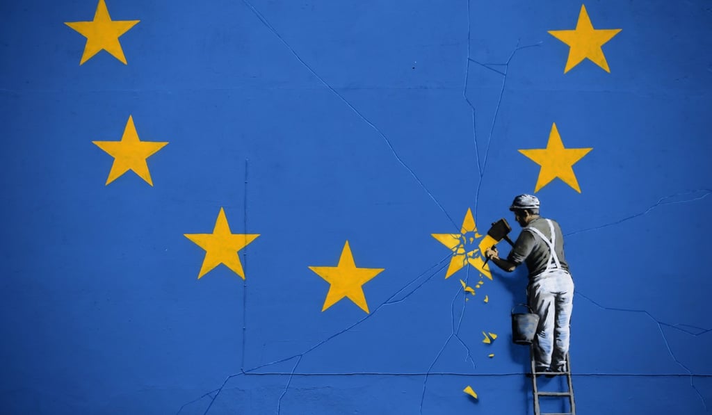 A mural painted by British graffiti artist Banksy, depicting a workman chipping away at one of the stars on a European Union flag. Photo: AFP