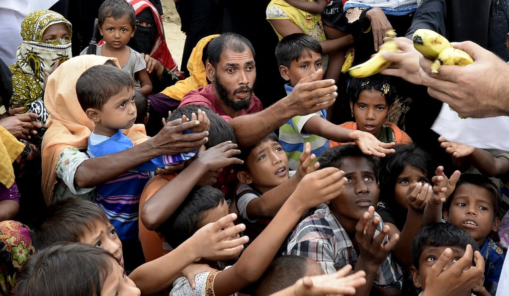 Rohingya refugees receive bananas from Bangladeshi volunteers after crossing from Myanmar. Photo: AFP
