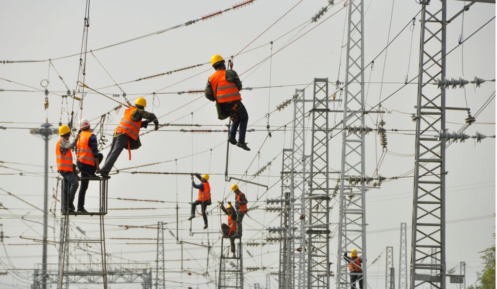 Workers install power lines at a railway station in Ankang, Shaanxi province, last month. Photo: Reuters