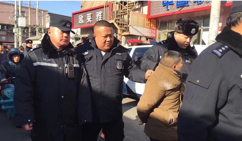 A protester is led away by police during the rally in Chaoyang district. Photo: Weibo