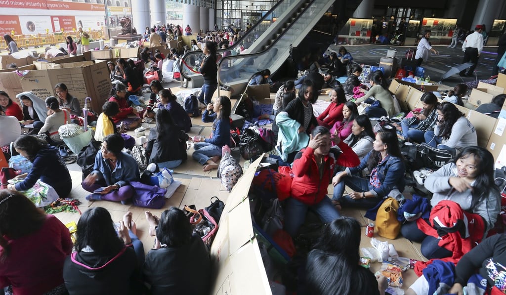 Filipino domestic helpers gather on a street in Hong Kong’s Central district in November. The sheer number of domestic helpers in Hong Kong has led to troubling social issues related to their treatment and to their treatment of children. This reliance on helpers has also had a huge impact on families. Photo: Dickson Lee