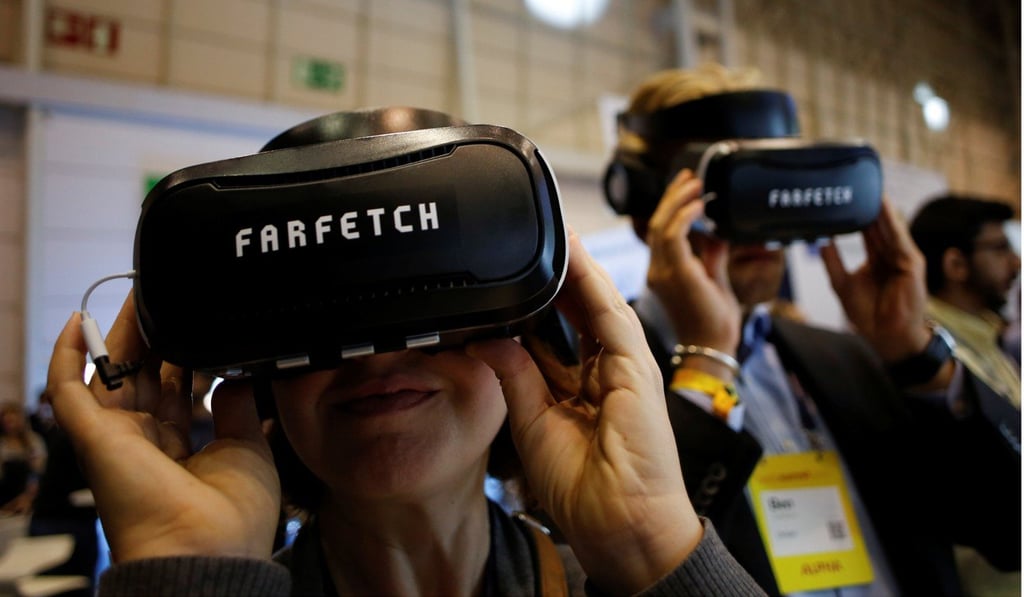 Visitors wear virtual reality glasses at the Farfetch stand during the Web Summit, Europe's biggest tech conference in Lisbon, Portugal. Photo: Reuters