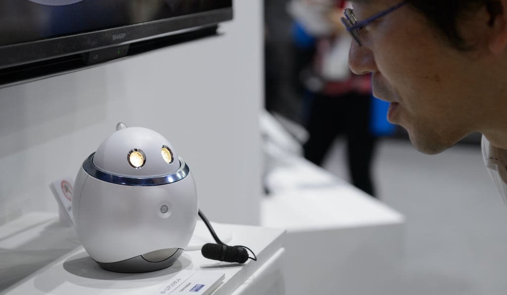 An employee demonstrates Sharp Corp.'s Home Assistant smart robot prototype at the company's booth at the CEATEC Japan 2017 exhibition in Chiba, Japan, on Monday, Oct. 2, 2017. Photo: Bloomberg