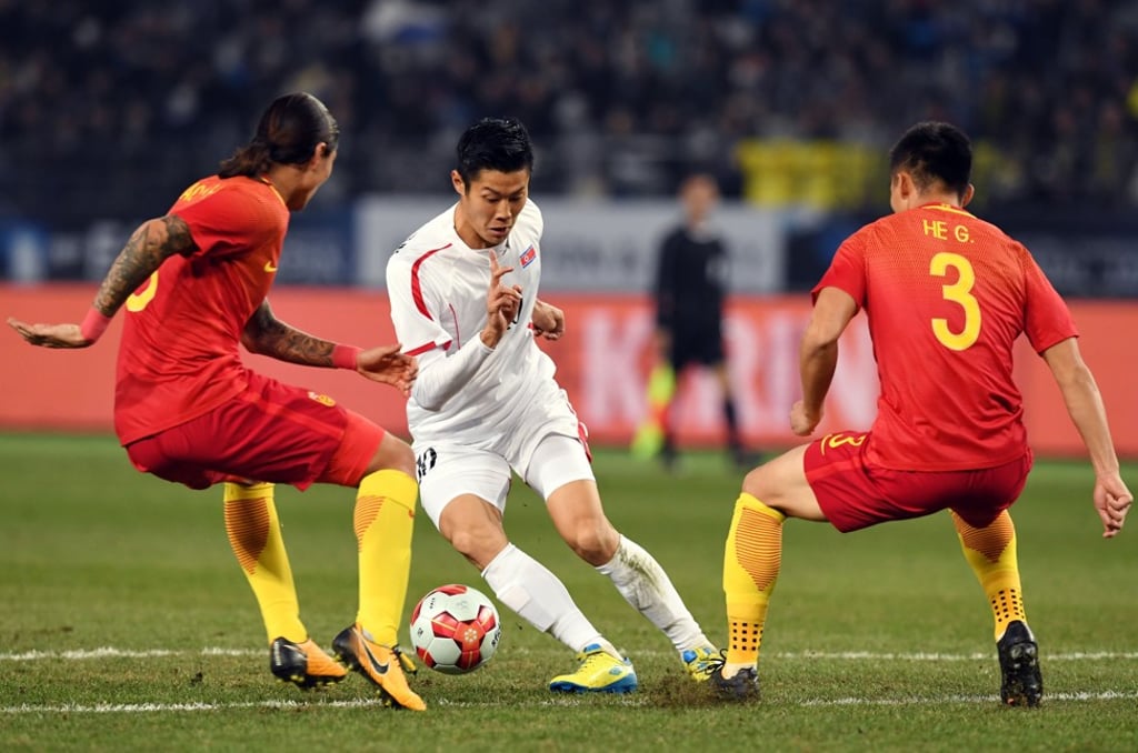 North Korea's An Byong-jun dribbles away from China's Zhao Yuhao and He Guan. Photo: AFP