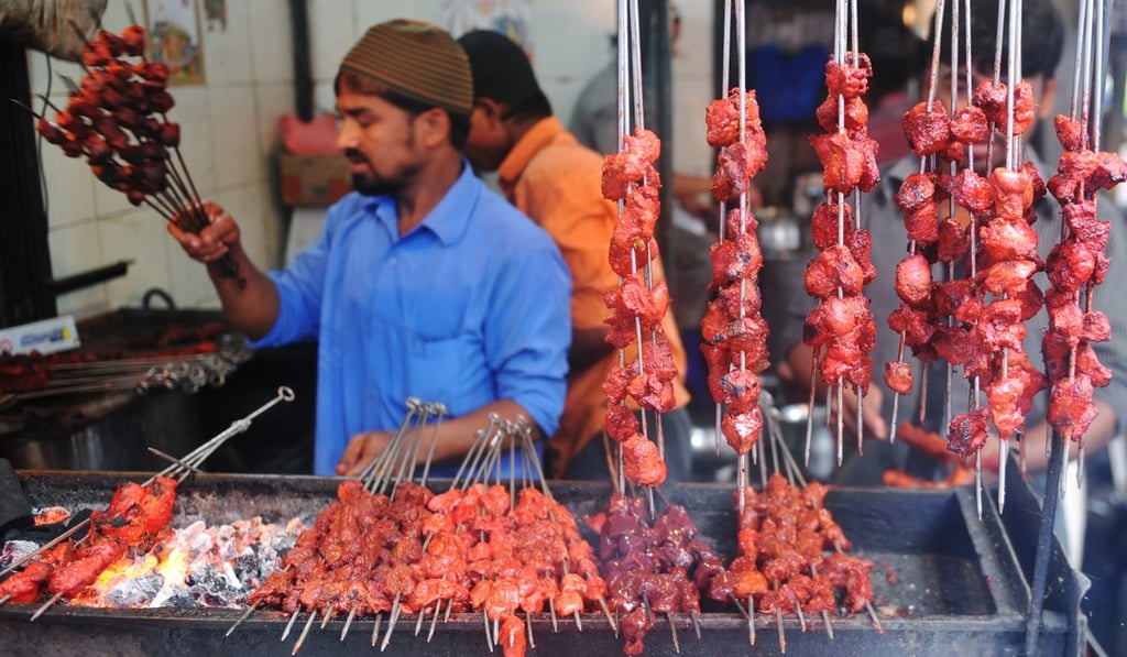 An Indian Muslim vendor grills meat kebabs over burning coals at a roadside stall. Photo: AFP