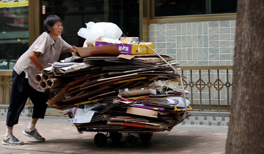 An elderly woman collects cardboard in Hong Kong. The poverty rate among one-way permit holders is much higher than that among the general population. Photo: Reuters