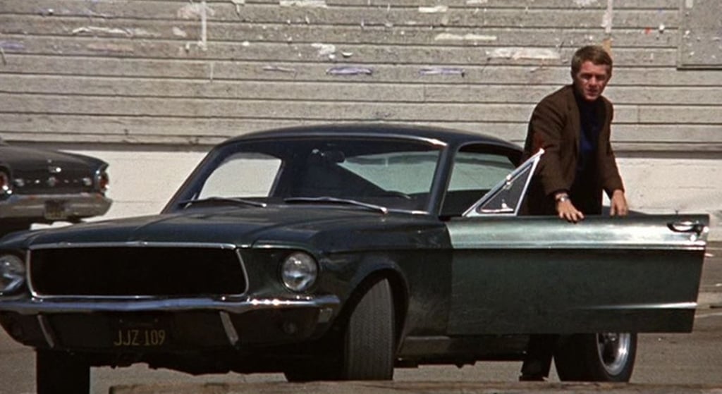 Steve McQueen beside the iconic 1960s Ford Mustang in a scene from the 1968 film ‘Bullitt’. Photo: Warner Bros