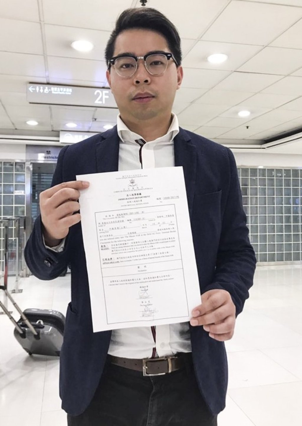 Third Side vice-chairman Capser Wong Chun-long showed reporters a document from the Macau authorities saying he was barred from entering the city. Photo: Handout