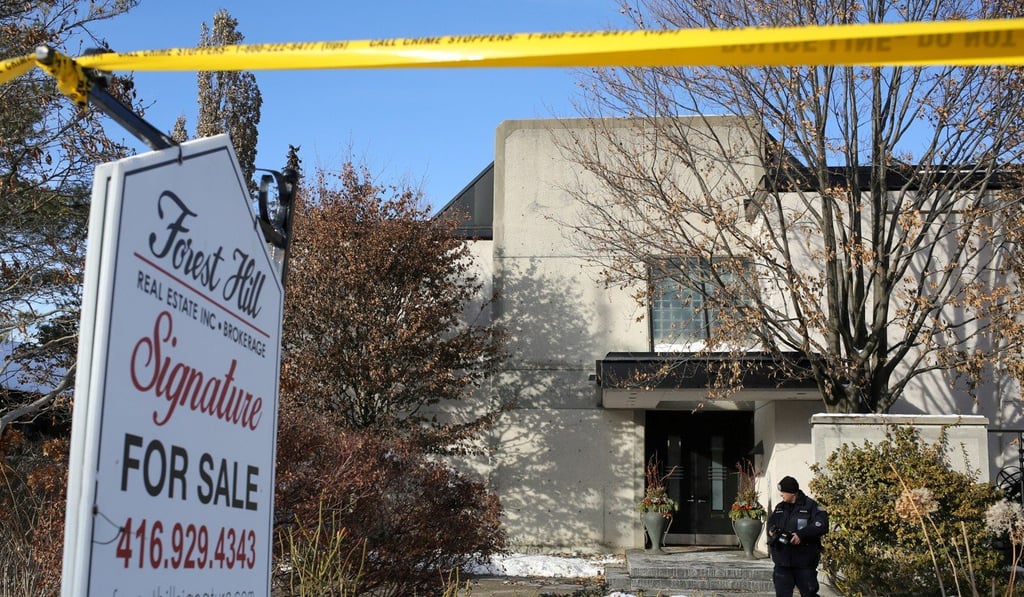 A police forensics photographer works outside the home of Barry Sherman and his wife Honey, who were found dead under circumstances that police described as suspicious, in Toronto, on Saturday. Photo: Reuters