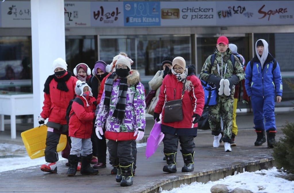 Tourists wear thick hooded jackets and scarves to protect themselves from the cold temperatures at Yongpyong Resort in Pyeongchang, South Korea. Photo: AP