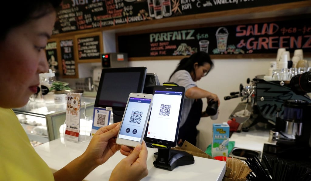 Frances Sy pays for her coffee with cryptocurrency at the opening of Ducatus cafe, the first cashless cafe that accepts cryptocurrencies, in Singapore on December 21, 2017. Photo: Reuters