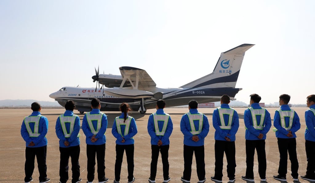 Ground staff stand in front of the AG600 at Zhuhai airport. Photo: Reuters