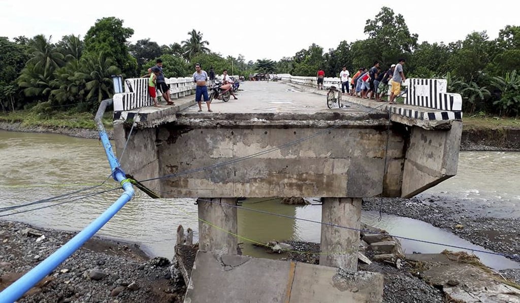 People gather on a bridge which was damaged by Tembin. Photo: AP