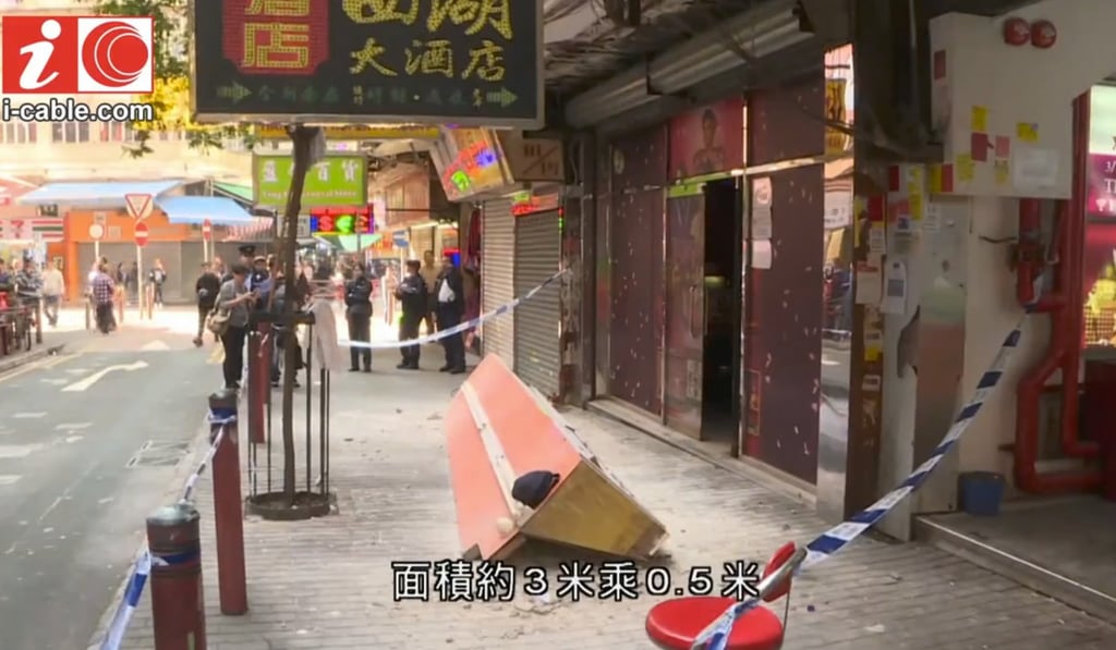 A shopkeeper was arrested after a sign fell on Nanking Street. Photo: CABLE TV NEWS