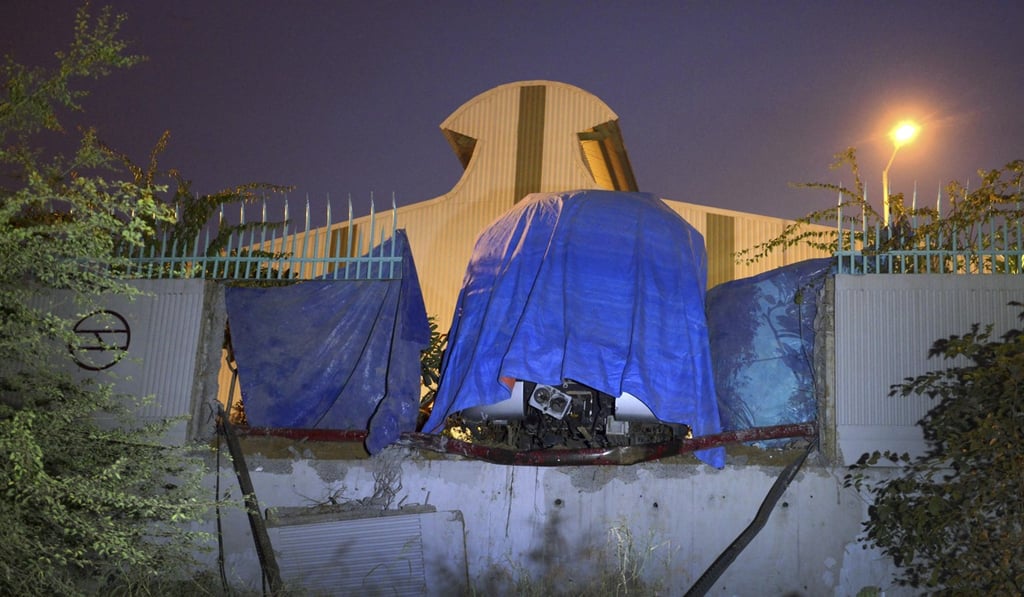 A Delhi metro train is seen covered under a blue plastic sheet after it crashed into the wall of its depot in New Delhi. Photo: AP
