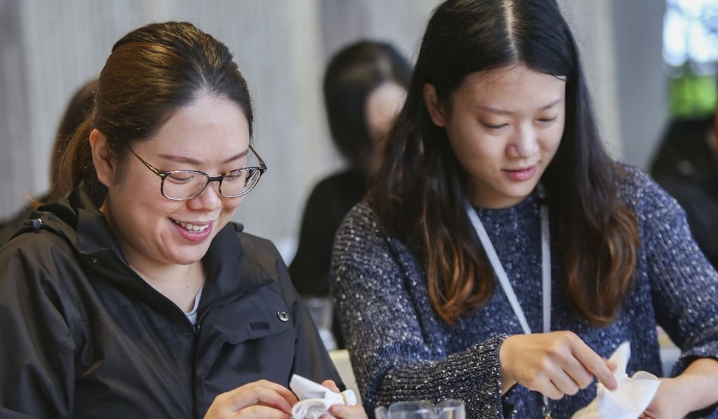 Volunteers Latina Leung Ka-ki (left) and Camille Wong Lai-ming (right) learn how to dye handkerchiefs. Photo: Xiaomei Chen