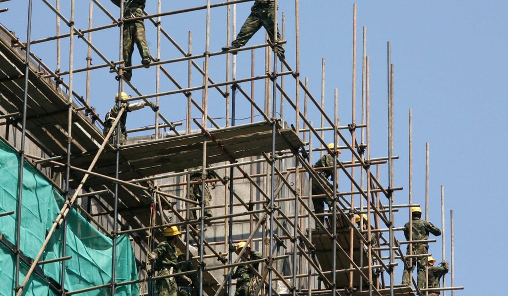 Workers install scaffolding outside a building for a renovation in Beijing. Photo: Reuters