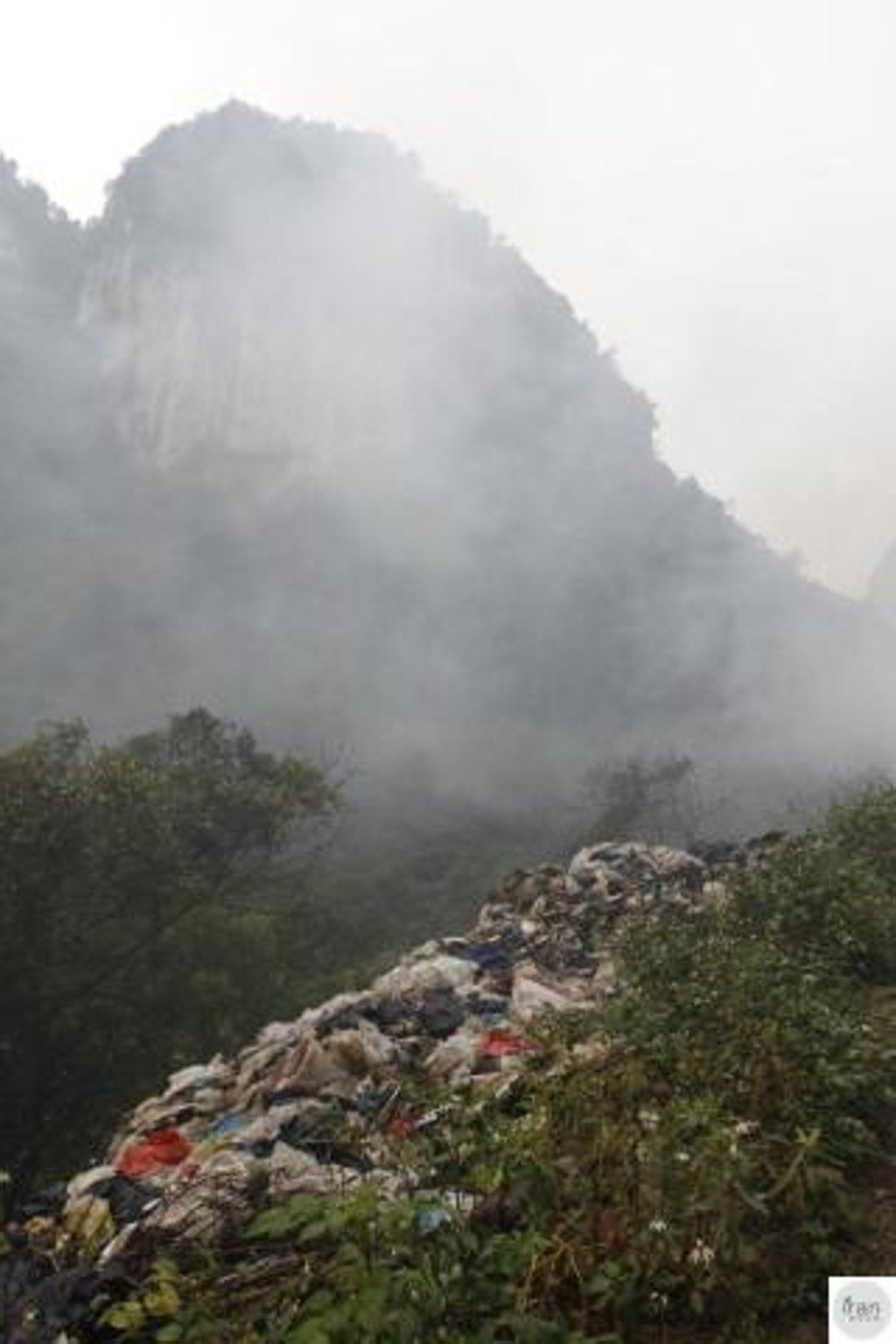 Rubbish litters a hillside near the area’s scenic mountains. Photo: Qq.com