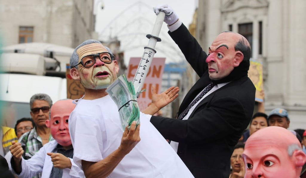 Actors wearing masks depicting Peru’s President Pedro Pablo Kaczynski and former president Alberto Fujimori perform during the march. Photo: Reuters