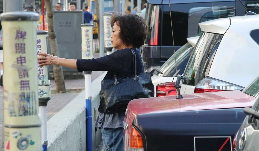 A woman pays for her parking fare in a parking meter at Victoria Park in Causeway Bay. Photo: K Y Cheng