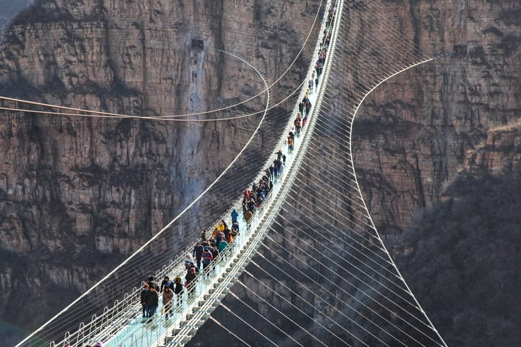 Tourists walk on the glass suspension bridge at Hongyagu Scenic Area. Photo: Xinhua Tourists walk on the glass suspension bridge at Hongyagu Scenic Area. Photo: Xinhua