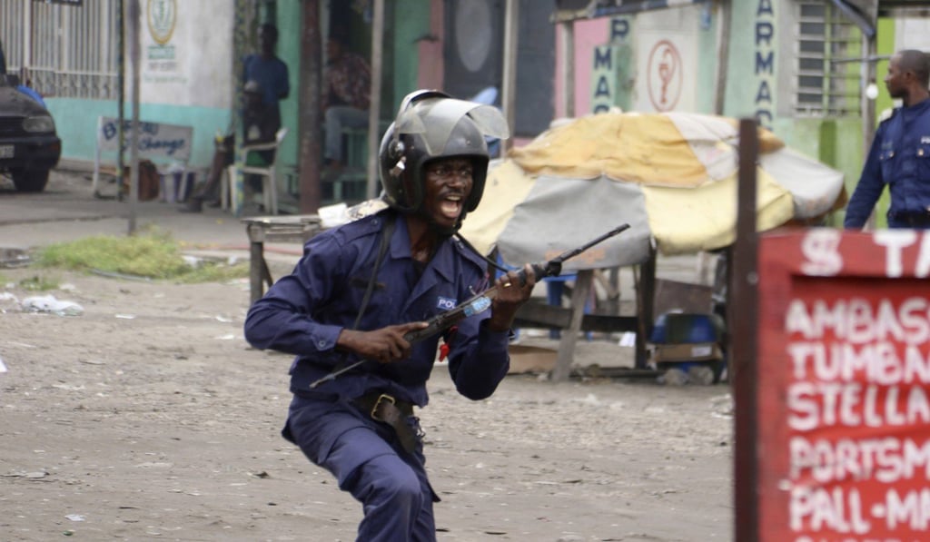 A member of the Congolese security forces chases people during a protest in Kinshasa. Photo: AP