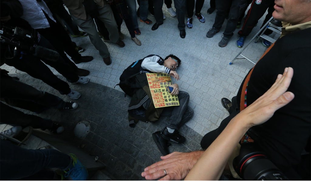A protester takes to the ground to make his point. Photo: Felix Wong