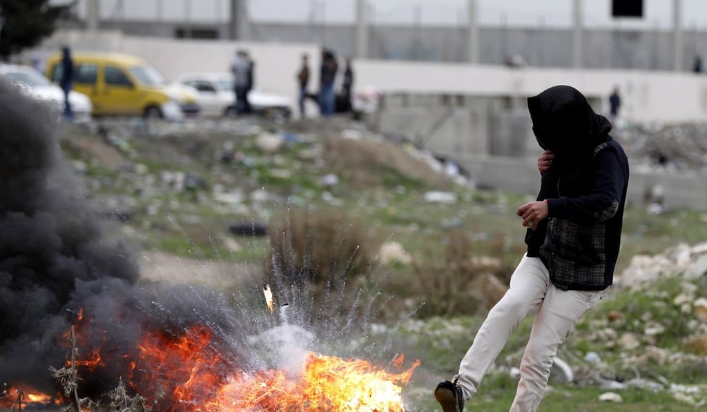 A Palestinian kicks a burning tyre during clashes in al-Fawwar refugee camp, south of the West Bank city of Hebron. Clashes have erupted as part of ongoing protests were held against US President Donald Trump's announcement he is recognising Jerusalem as Israel’s capital. Photo: EPA-EFE A Palestinian kicks a burning tyre during clashes in al-Fawwar refugee camp, south of the West Bank city of Hebron. Clashes have erupted as part of ongoing protests were held against US President Donald Trump's announcement he is recognising Jerusalem as Israel’s capital. Photo: EPA-EFE
