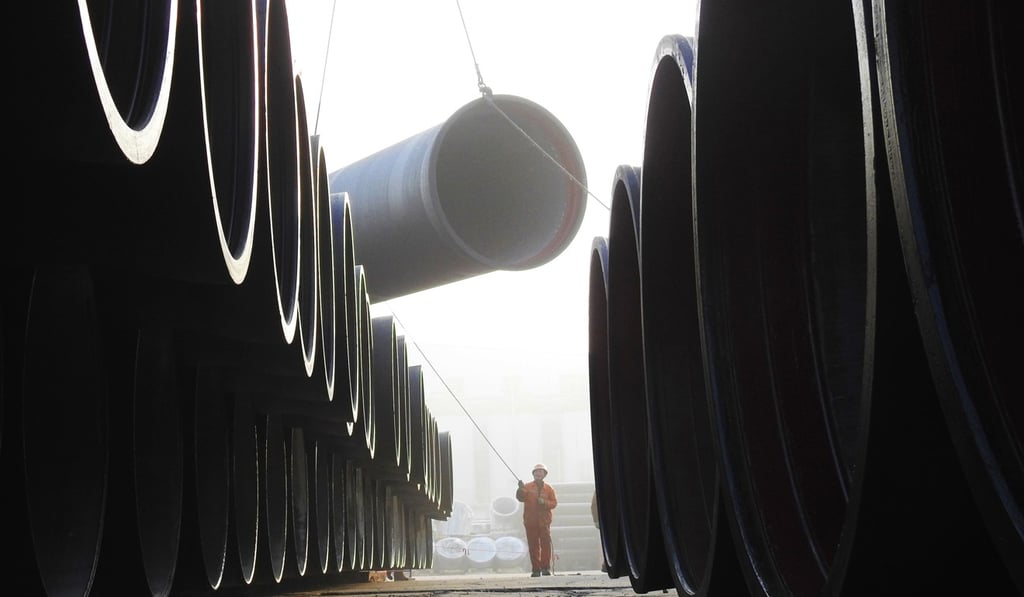 A worker loads cast iron pipes at a port in Lianyungang, Jiangsu province, on December 31. Since late 2013, investment growth in China has been declining steadily, and growth in net exports, too, seems unlikely to offset declining investment. Photo: AFP