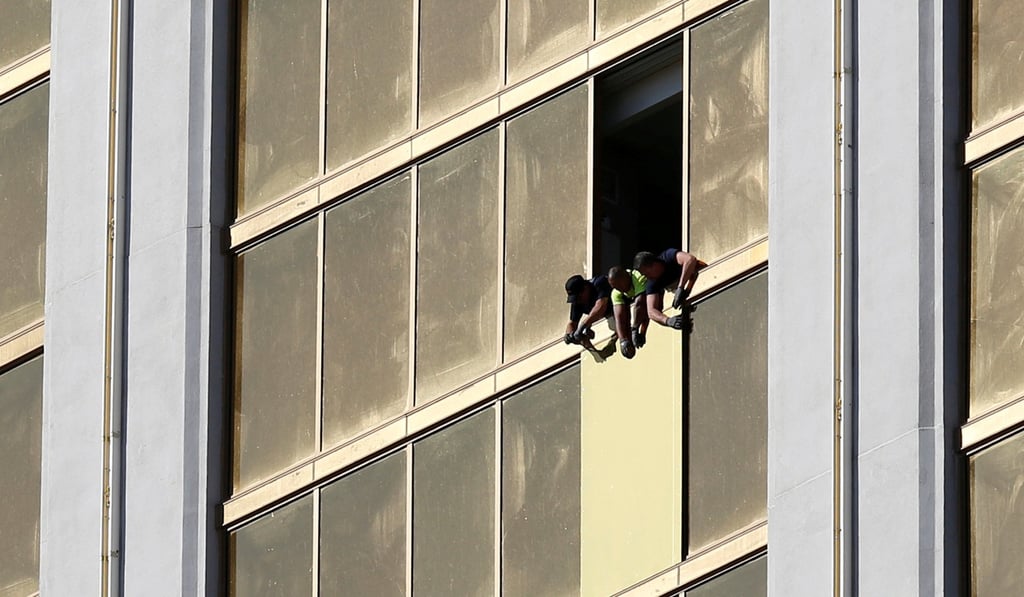 Workers board up a broken window at the Mandalay Bay hotel. Photo: Reuters